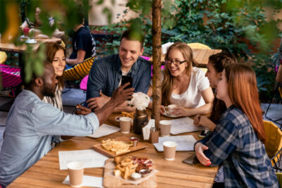 grupo de pessoas em um restaurante olhando celular