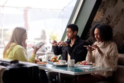 pessoas em restaurante usando midia como ferramenta de visibilidade