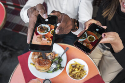 pessoas tirando foto de comida em restaurante